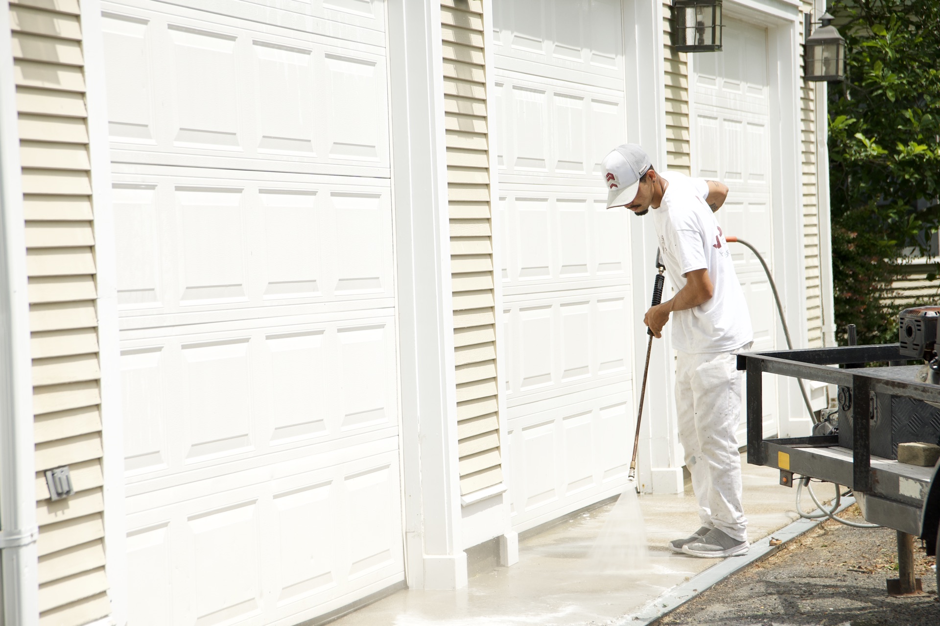 Crew soft washing a garage door and siding